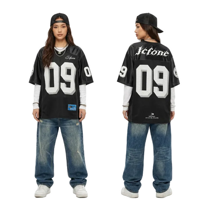 Front and back view of a model in an oversized black 09 graphic jersey and baggy vintage denim jeans for a Y2K streetwear look.