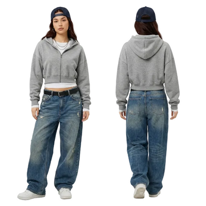 Front and back view of a model wearing a grey cropped zip hoodie and baggy vintage wash denim jeans for a Y2K streetwear outfit.