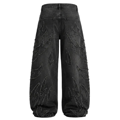 Back view of baggy washed black denim jeans with flame embroidery patches and a wide-leg Y2K streetwear fit.
